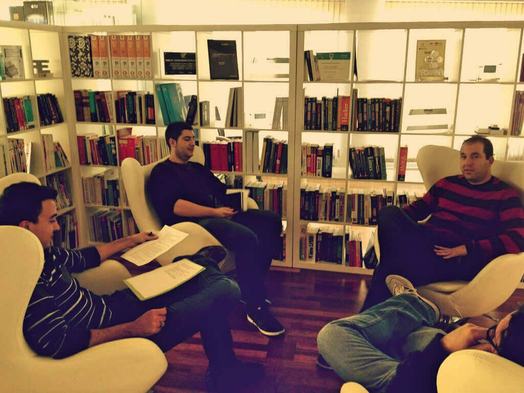 Compañeros de Neosistec sentados en la biblioteca de la oficina